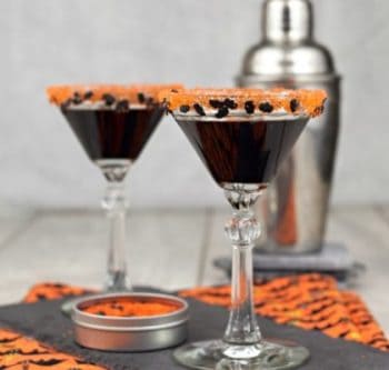 This Black Martini recipe is a great drink for any dark occasion, including your Halloween party. While there are many black martini cocktail recipes out there, this one was inspired by our son-in-law, who loves classic German licorice. We use Black Sabuca in this drink recipe, which is an anise-flavored liqueur that deep blue in color and made by the infusion of witch elder bush and licorice. It gives our Black Martini recipe a dark twist, one that's both spooky and elegant for your All Hallows Eve party. This cocktail recipe is just for grown-up goblins: Serve up a little black magic in a glass, that's dark as the night. The cocktail sugar rimmer can be a little challenging to get right, because of the tiny black bat-shaped candy sprinkles. In order to get them to stick, you will need to brush honey or corn syrup onto the rim of your glasses.