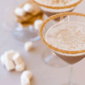 A S'mores martini is an adult s'mores treat, with the sweetness of a marshmallow martini and the richness of a chocolate martini. Essentially, it is dessert in a glass. After all, what says summer more than s'mores? You’ll need some marshmallow vodka, a bit of chocolate – and dream of late nights under the stars.